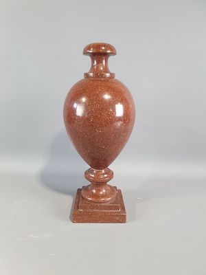 a brown vase that is sitting on a white table