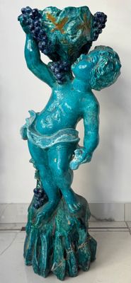une statue représentant une femme tenant une grappe de raisin