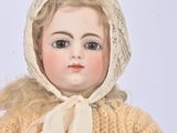 a doll that is wearing a sweater and a hat