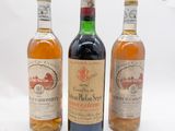 trois bouteilles de vin posées les unes à côté des autres sur une surface blanche