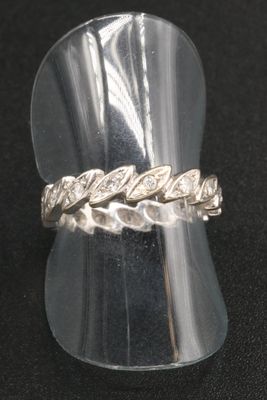 silver ring with a braid design on top of it on a black surface