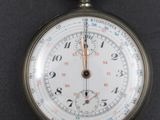 a close up of a pocket watch on a black surface