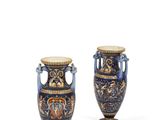 une paire de vases bleus et dorés posés sur une surface blanche