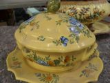 a yellow dish with a bird sitting on top of it