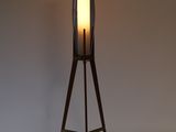 a wooden floor lamp with a glass shade on top of it
