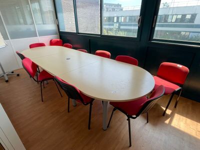 a long table with red chairs in the middle of a room