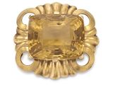 a close up of a yellow stone broochle on a white background