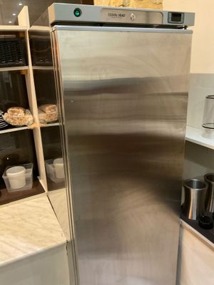 a stainless steel refrigerator in the corner of a kitchen