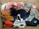 a cardboard box filled with clothes and other items
