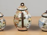 three small vases sitting on a table next to each other