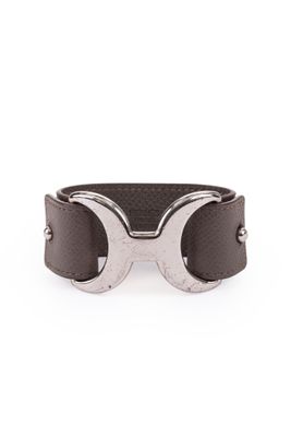 a close up of a brown leather bracelet with two metal rings on it