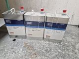 trois bidons de liquide posés par terre