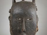 an old wooden mask with horns on display in a museum