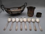 several silver spoons and a bowl are sitting on a table