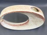 a white vase with a hole in it on a table