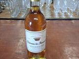 une bouteille de vin posée sur une table, avec des verres en arrière-plan