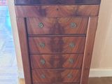 une petite commode en bois posée sur un parquet en bois dur
