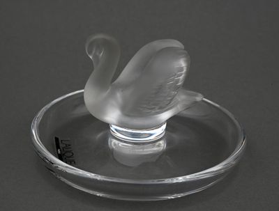 un cygne en verre posé sur une assiette en verre