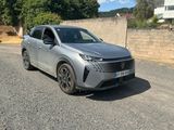 un SUV argenté garé sur un parking, à côté d'un mur en pierre
