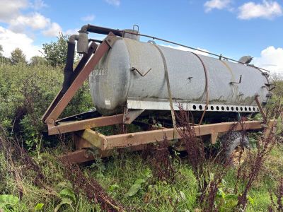 a large tank sitting on a trailer in the middle of a field