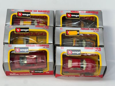 trois boîtes contenant des petites voitures rouges, posées sur une surface blanche