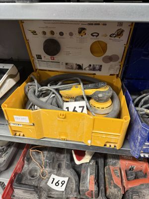 une boîte à outils jaune remplie d'outils, posée sur une étagère