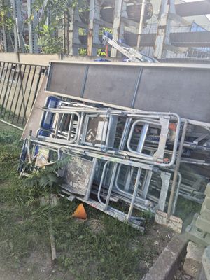 a pile of chairs and a fence in the yard