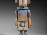 une vieille figurine en bois représentant un homme coiffé d'un casque