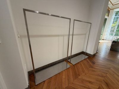 une photo d'une pièce avec un grand miroir accroché au mur