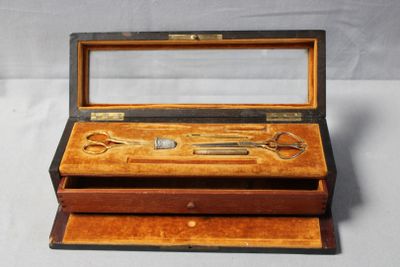 a wooden box with a pair of scissors in it