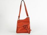 an orange leather handbag on a white background