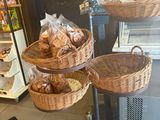 several baskets of bread are stacked on top of each other in front of a refrigerator