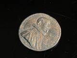 une pièce d'argent sur laquelle figure l'image d'un homme
