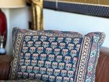 un canapé en cuir marron avec un coussin bleu et rose
