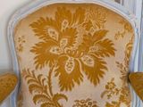 a chair that has a yellow and white floral pattern on it