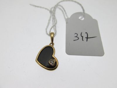 une photo d'un pendentif noir en forme de cœur sur lequel est accrochée une étiquette de prix