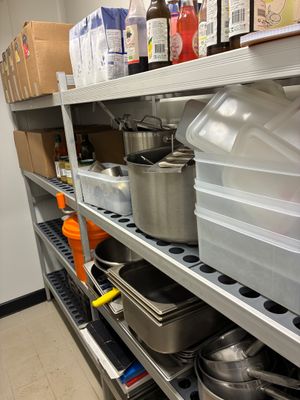 de nombreuses casseroles et poêles sur les étagères de la cuisine