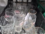 bottles and glasses in a dishwasher basket on a counter
