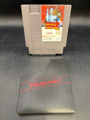 Un vieux jeu Nintendo est posé sur une table, à côté d'un livre.