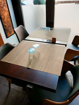 une table et des chaises dans une pièce avec une grande fenêtre