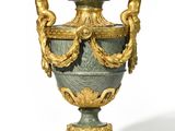 une urne dorée et verte ornée de deux cherns