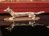 a silver dog figurine sitting on top of a red box