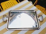 a silver tray on a table with a mirror on it