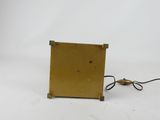 an image of a small gold clock with a black cord