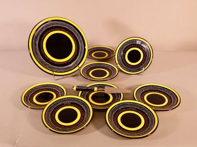 yellow and black plates with black rims on a white surface