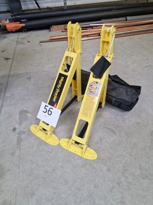 a yellow caution sign on the ground next to a black bag
