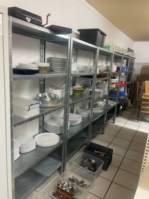 beaucoup d'assiettes et de casseroles sur les étagères de la cuisine