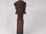 a small wooden object with a face on top of it