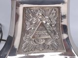 a close up of a silver plate with a masonic symbol on it