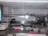 une grande cuisine avec des plans de travail et des appareils électroménagers en acier inoxydable